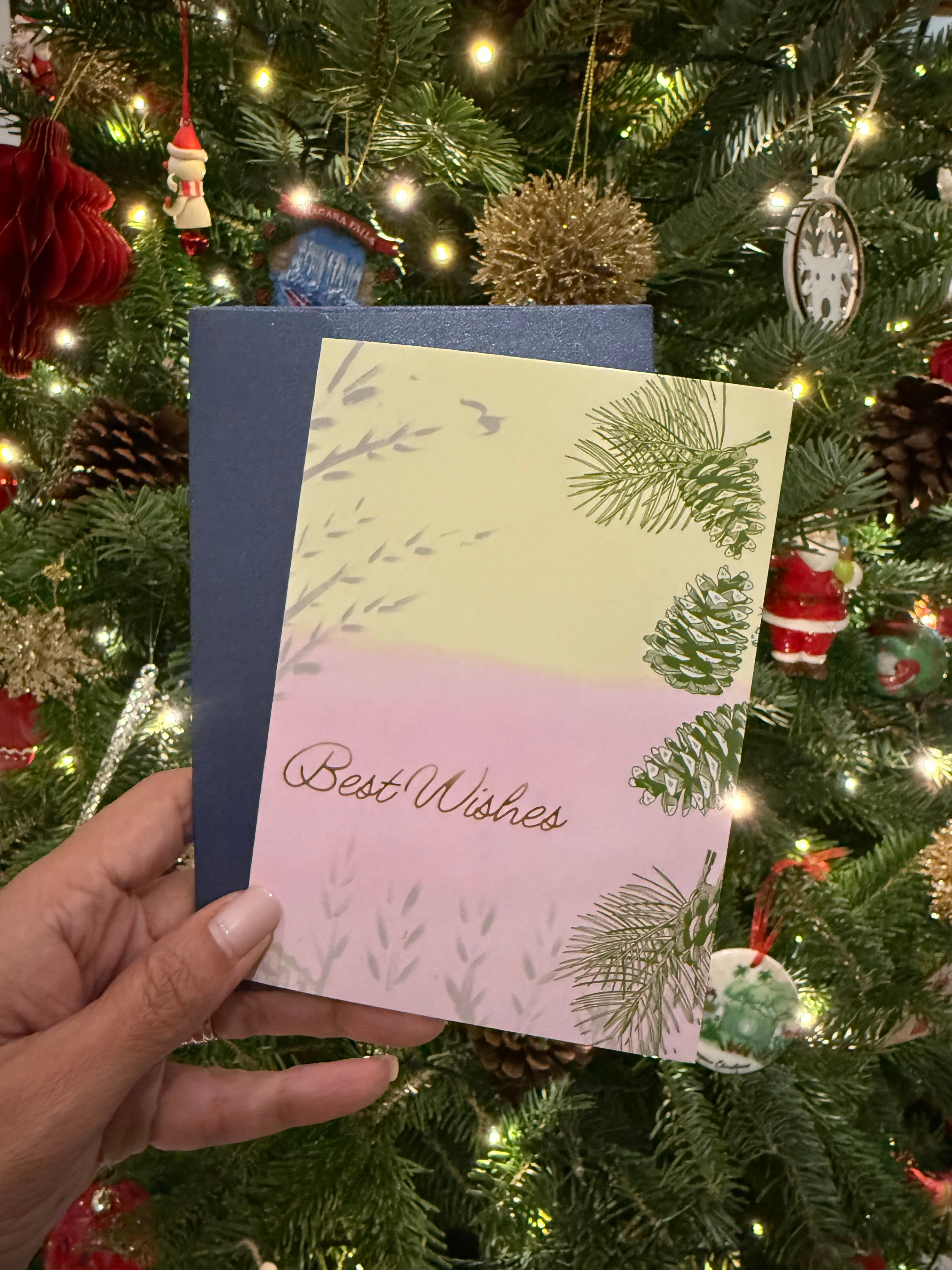 Christmas card with 'Best Wishes' in front of a decorated Christmas tree.